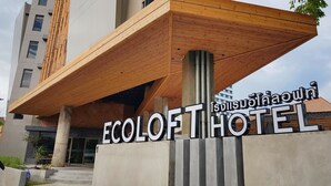 The entrance of ECOLOFT HOTEL with a modern design, featuring a prominent wooden overhang and a sign with Thai script. - EcoLoft Hotel (Phuket)
