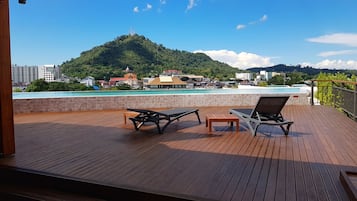 Una piscina al aire libre, sillones reclinables de piscina