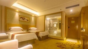 A hotel room with two beds, a sitting area, and a bathroom visible through a glass door. - Vienna Hotel (Sanya Yalong Bay Qianguqing) (Sanya)