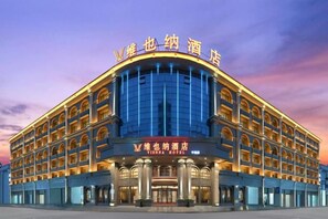 A multi-story hotel with a curved facade, multiple balconies, and a prominent entrance.