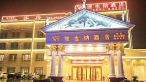 A hotel entrance with a prominent sign, a statue, and a well-lit facade. - Vienna Hotel (Shanghai Wild Animal Park Metro Station) (Shanghai)