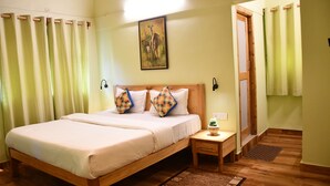 Une chambre à coucher avec un lit en bois, une table de chevet, une petite table sur laquelle est posée une plante, et une porte qui donne sur une autre pièce.