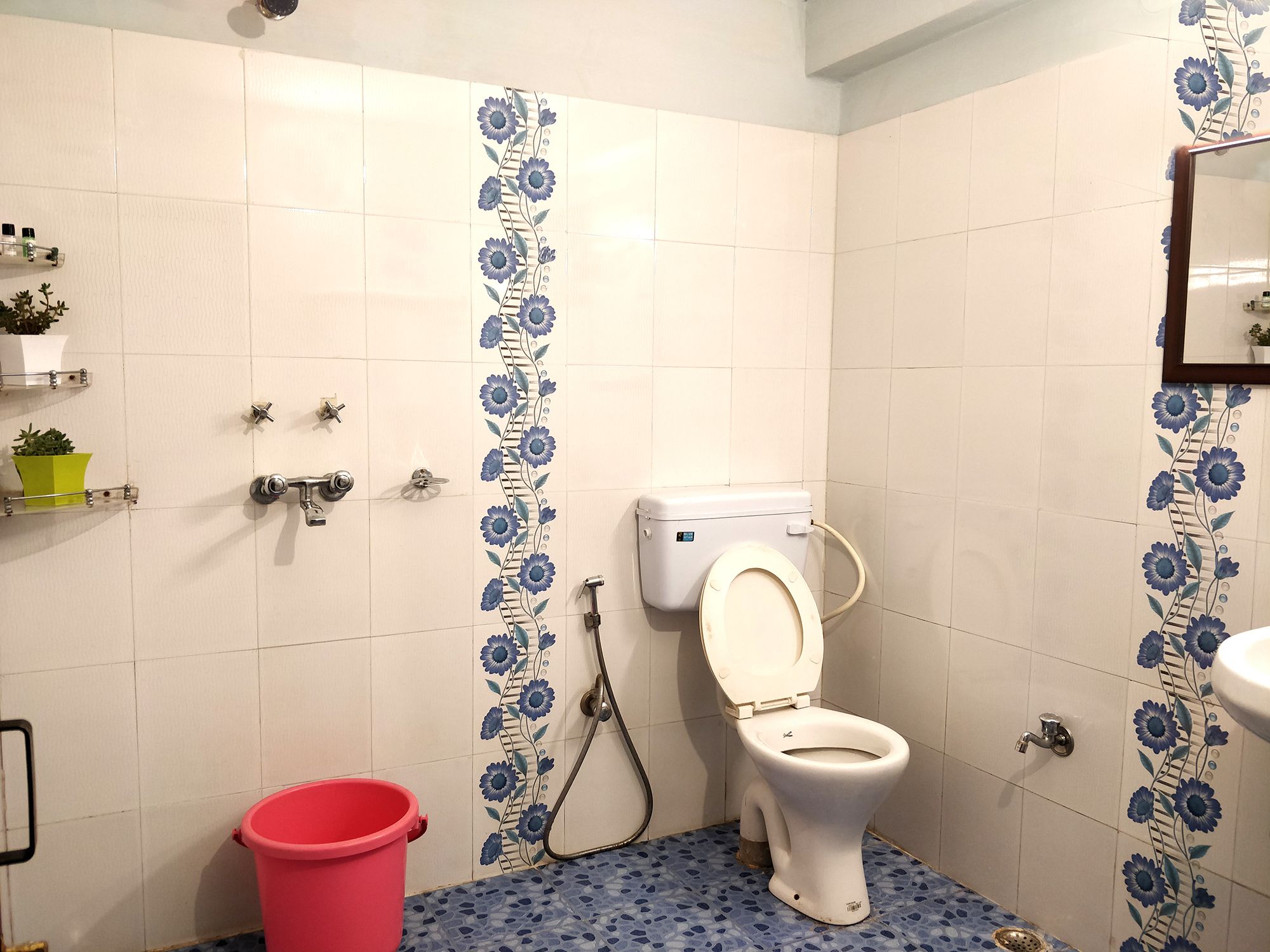 A bathroom with a toilet, shower, and sink.