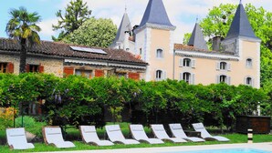 Una piscina al aire libre, sillones reclinables de piscina