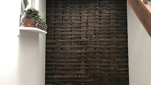 A staircase with a wooden handrail leading to a dark brick wall. - Casa da Picaria (Porto)