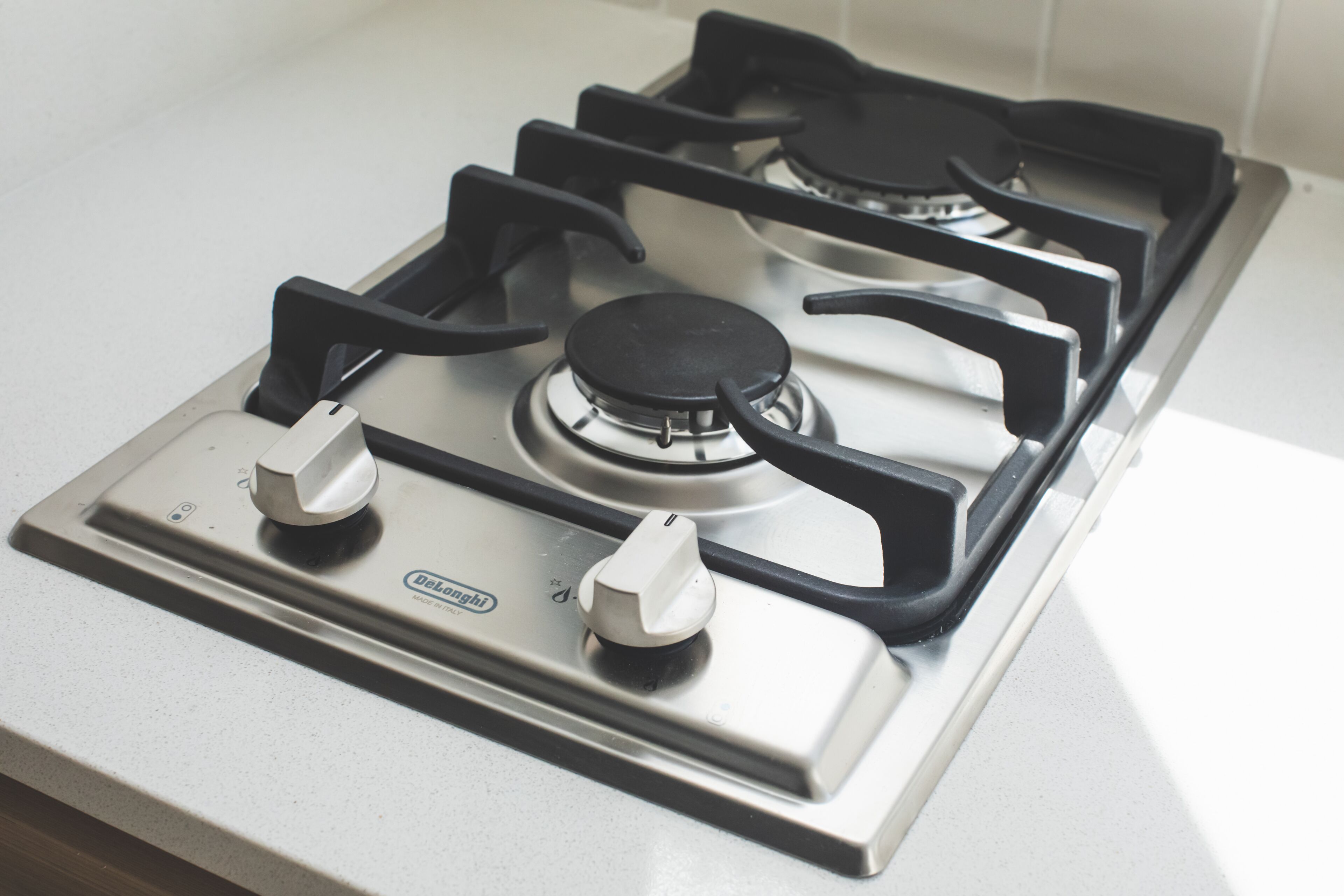 A Delonghi gas stove with four burners and two knobs.