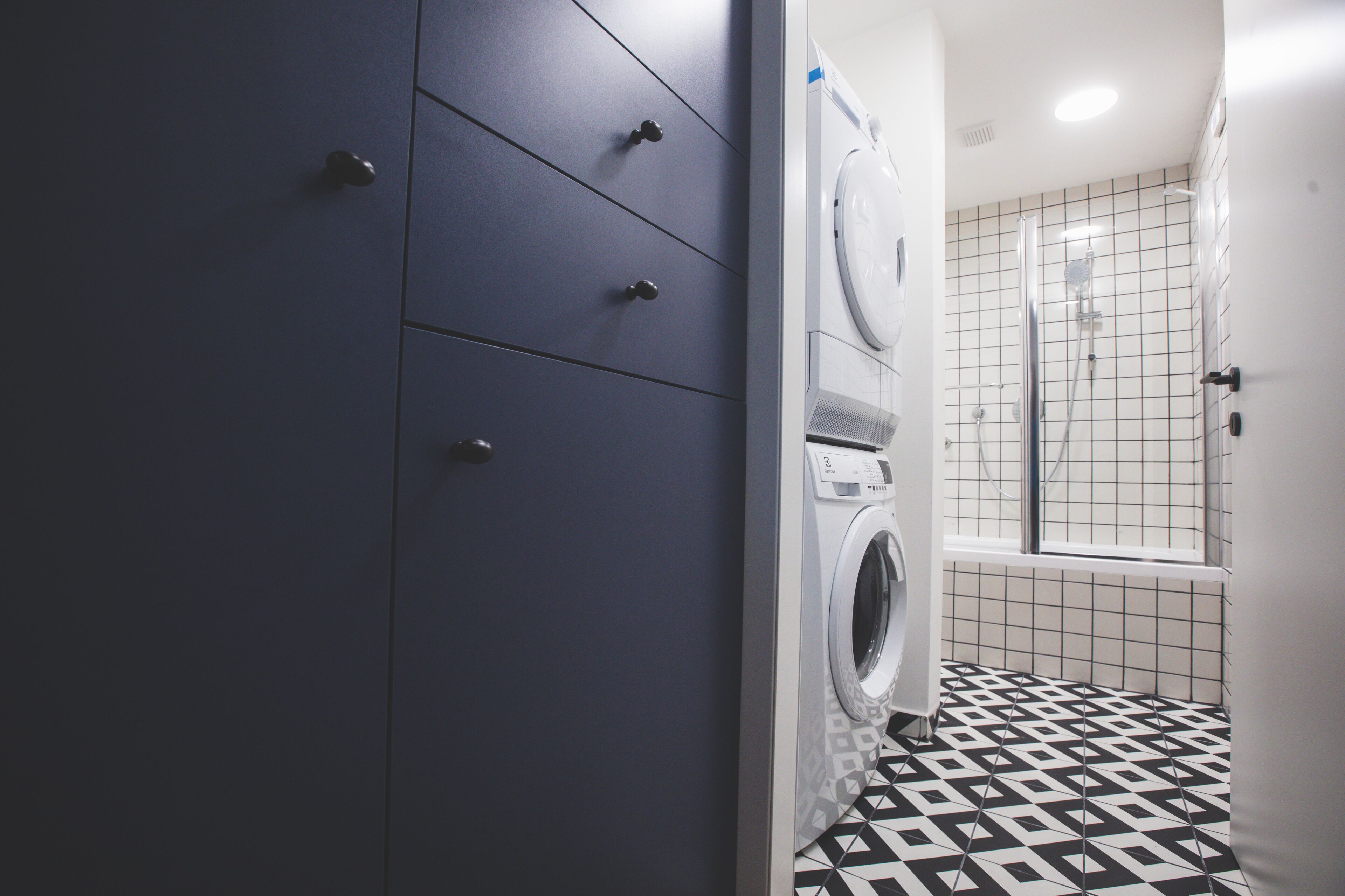 A laundry room with a washing machine, a dryer, and a tiled floor.