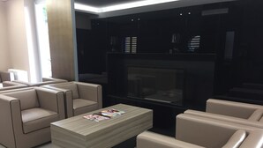 Una sala de estar moderna con chimenea, sofás de cuero y una mesa de centro.