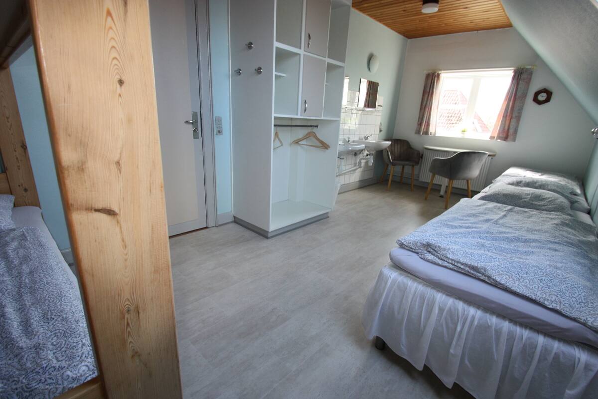 Quarto com cama, escrivaninha e guarda-roupa.