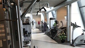 A gym with various exercise equipment, including a stationary bike, elliptical, and weight machines. - Bredebro camping (Bredebro)
