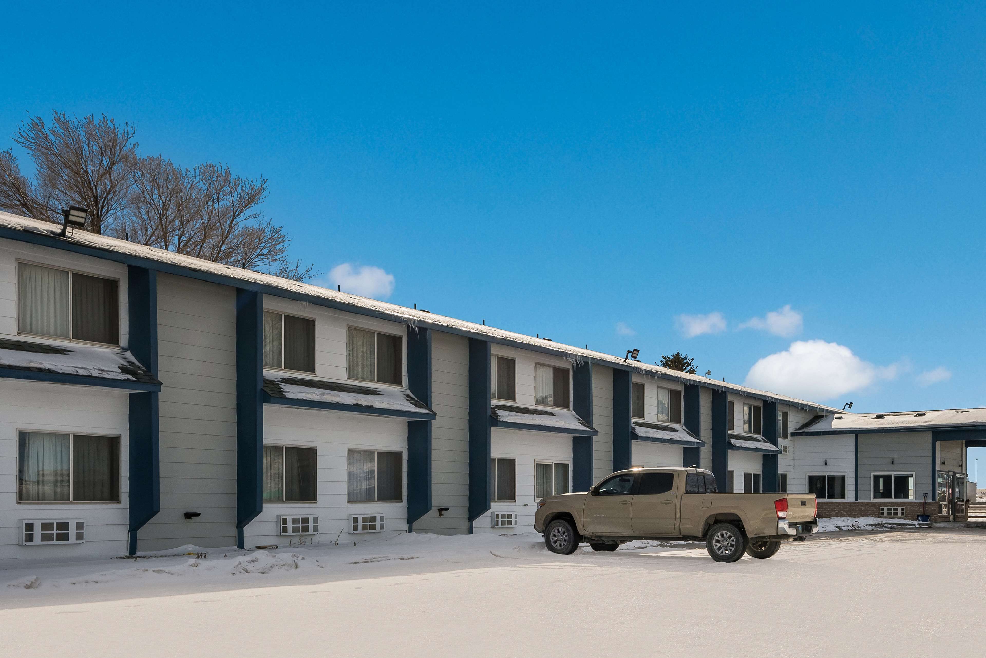 Un motel de varios pisos con una fila de habitaciones, cada una con ventana y puerta.