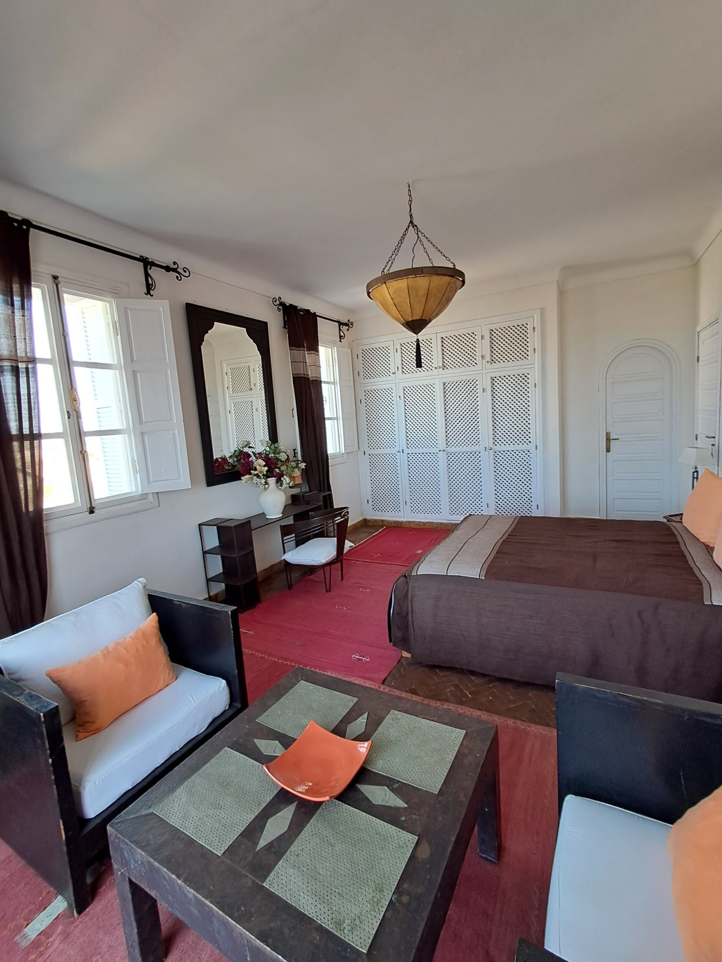 Ein Hotelzimmer mit Bett, Sofa, Couchtisch, Schreibtisch und Stuhl.