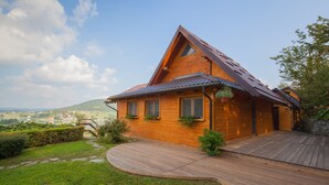 A wooden cabin with a sloped roof, a wooden deck, and a view of a valley. - Lakefront Villa Jelenic By Bertovic in Croatia with a squash court, gym, cinema (Ogulin)