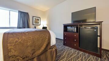 Ein Hotelzimmer mit Bett, Fernseher auf einem Schrank und einer Mikrowelle.