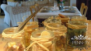 Un tavolo da pranzo con barattoli di vetro contenenti diversi alimenti, legati con lo spago.