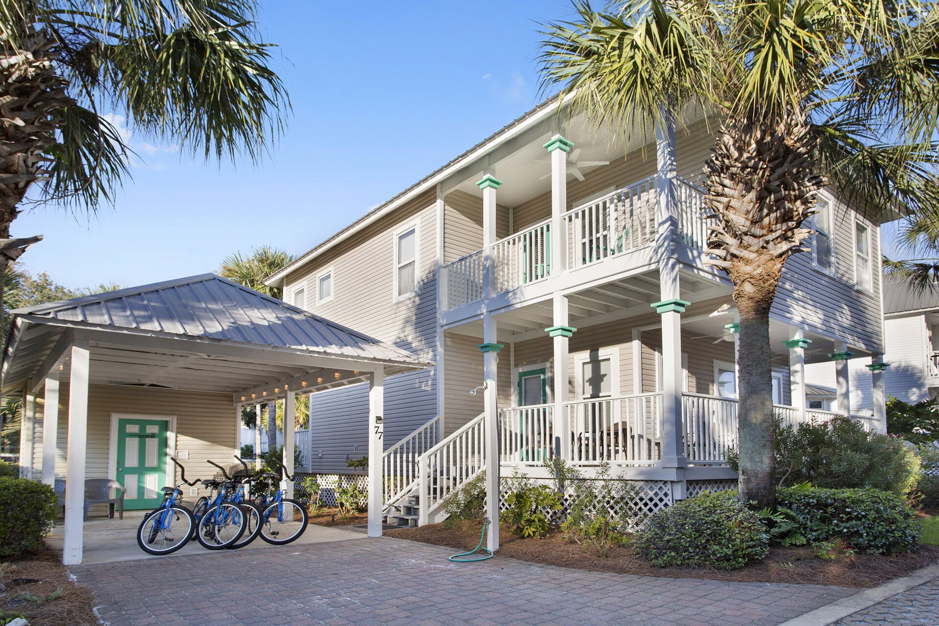 A two-story building with a covered porch and a staircase leading to the upper level.