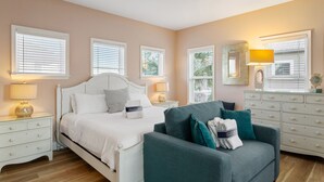 A bedroom with a bed, a sofa, a dresser, and a nightstand. - Eden's Estate - Pet Friendly, Heated Community Pool, Bikes Included! (Miramar Beach)
