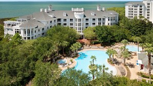A large resort with multiple swimming pools, a beach area, and ocean views.
