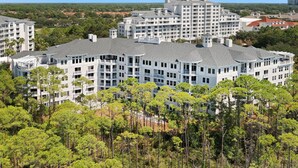 A multi-story hotel with a modern architectural design, featuring balconies and a central courtyard.