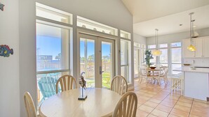 Una cocina amplia con ventanas grandes, un comedor con sillas y vistas al exterior.