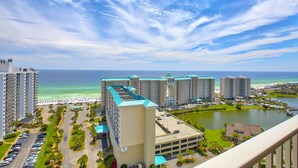 Un grand hôtel à plusieurs étages, doté d’un parking et offrant une vue sur l’océan et la plage.