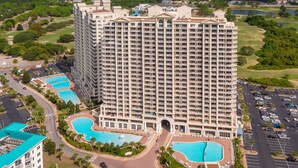 Un hôtel de grande hauteur doté de nombreux balcons, d’une cour intérieure et de deux piscines.