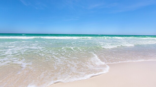 A beach with clear turquoise water and a sandy shore. - Hideout – Updated! Pet Friendly & Walk to Beach! (Destin)
