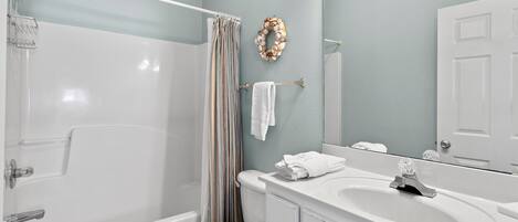A bathroom with a bathtub, toilet, and sink.