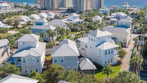 A coastal residential area with multiple-story houses, some with balconies, and a view of the ocean. - All 4 Fun - Gulfside Cottages, Community Pool, Steps to the Beach! (Miramar Beach)
