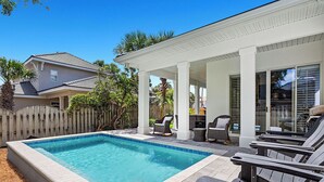 A backyard with a swimming pool, patio furniture, and a covered seating area. - Amazing Grace - Destiny West, Heated Private Pool, Fitness, Community Hot Tub! (Destin)