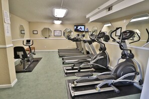 A fitness center with treadmills, ellipticals, and a stationary bike.