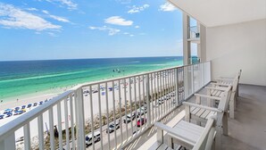 Un balcon avec vue sur une plage et l’océan.