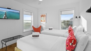 A hotel room with two beds, a TV, a ceiling fan, and a view of the ocean. - Averitts Favorite - Newly Renovated, Gulf View, Tang-O-Mar Community! (Destin)