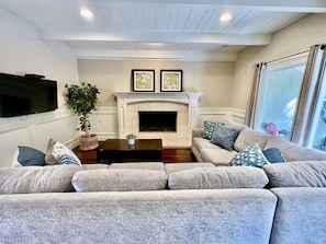 Relax by the fireplace in this cozy living space, featuring a plush sofa and flat-screen TV.