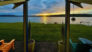 Un espace extérieur abrité offrant une vue sur un lac et le coucher du soleil.