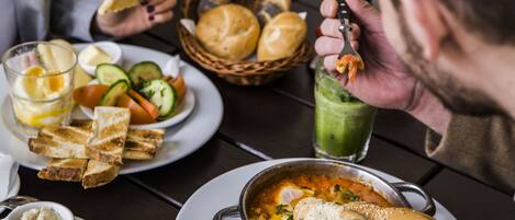 A dining table with a bowl of soup, bread, and various side dishes.