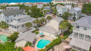A residential area with multiple two-story houses, a swimming pool, and a view of the ocean. - Sandy By The Sea - Blue Mountain Beach! Gulf View! Private Pool! Pet Friendly! (Santa Rosa Beach)