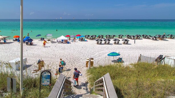 A beach with white sand, clear turquoise water, and several beach umbrellas. - Sandy By The Sea - Blue Mountain Beach! Gulf View! Private Pool! Pet Friendly! (Santa Rosa Beach)