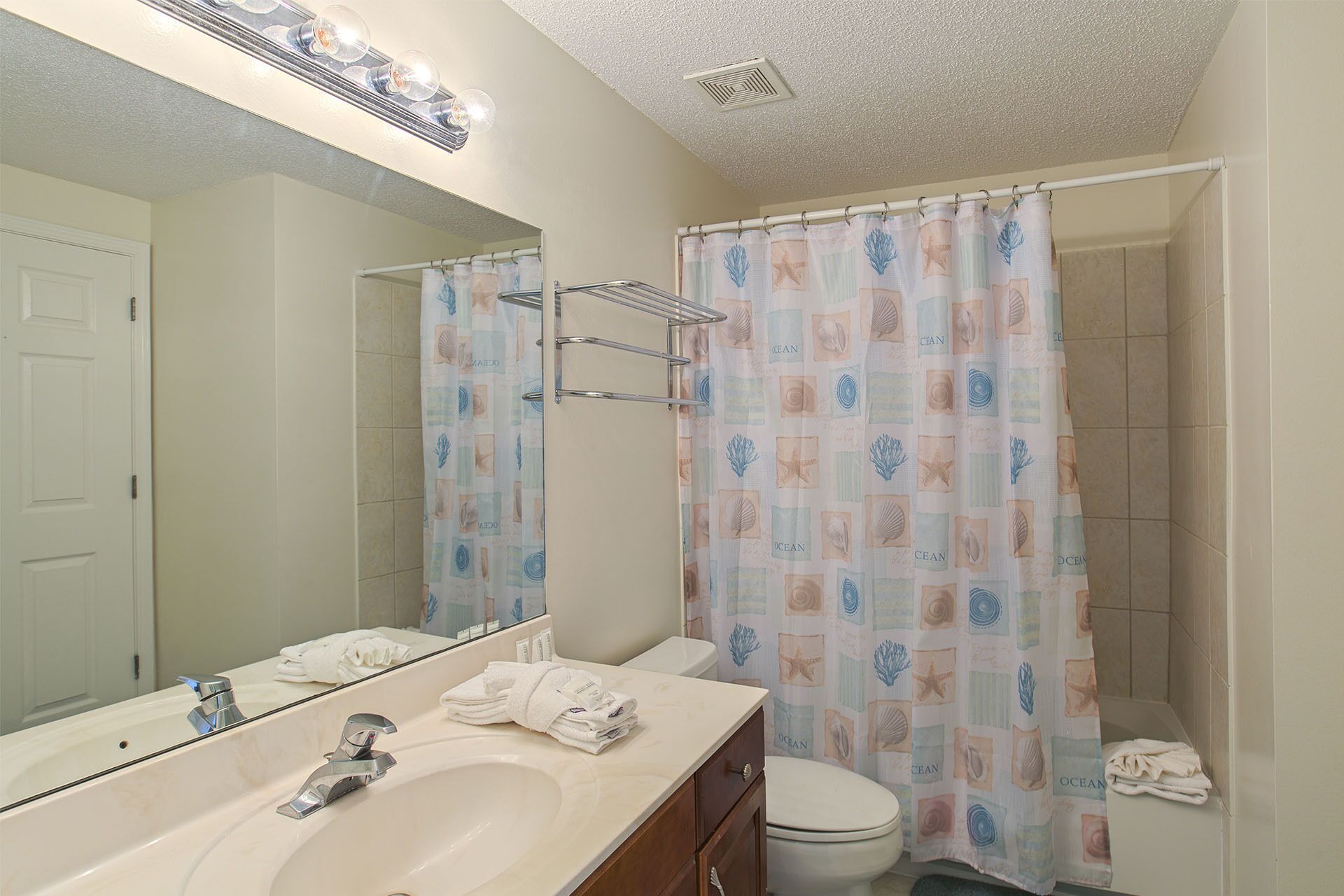Une salle de bain avec un lavabo, un miroir et des toilettes.