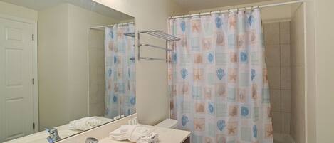 Une salle de bain avec un lavabo, un miroir et des toilettes.