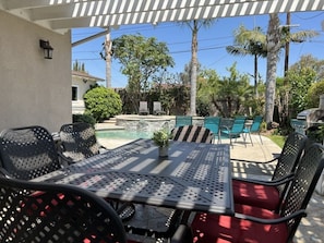 An outdoor patio with a table and chairs, a pool, and palm trees. - Awesome Pool/Jac Home: 2 Ensuites, Walk 2 Disney (Anaheim)