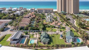 A resort with multiple buildings, a large pool, and a view of the ocean. - Panorama - Gulf Views! Heated Private and Community Pool! Free Beach Service! (Miramar Beach)
