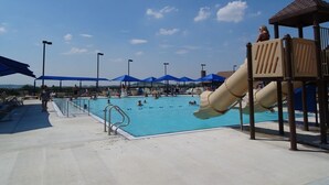 A swimming pool area with a slide, umbrellas, and a shaded seating area. - On The Golf Course, Outdoor Kitchen, Hot Tub and So Much More! (Galena)