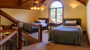 A bedroom with two beds, a staircase, and a large arched window. - On The Golf Course, Outdoor Kitchen, Hot Tub and So Much More! (Galena)