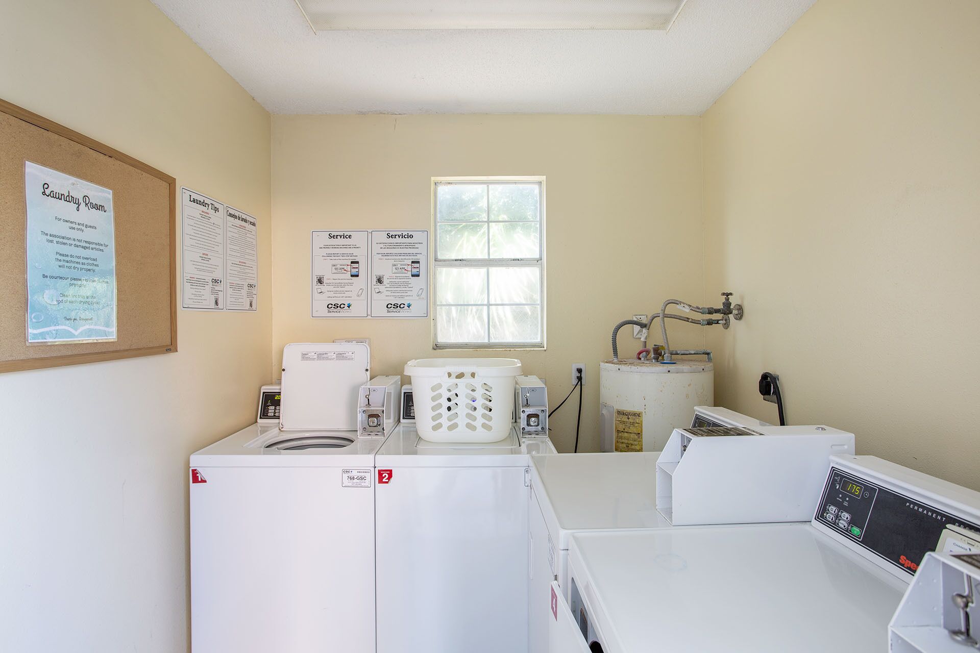 A laundry room with two washing machines, a dryer, and a permanent iron station.
