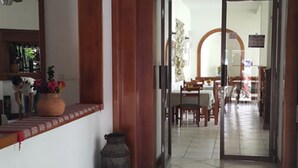 A hallway with a tiled floor, a wooden door frame, and a mirror on the wall. - Hotel Casa Flores De Tikal (Flores)