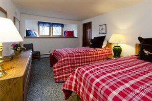 A room with two beds, a desk, a chair, a window with a view, and a lamp. - High Country Hideaway (Steamboat Springs)