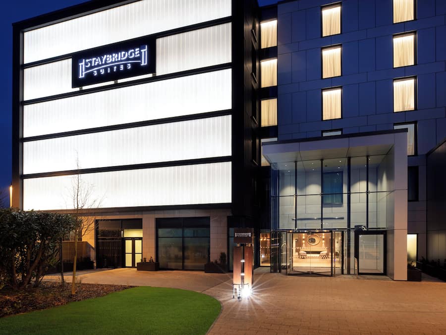 Un moderno edificio de hotel con un letrero llamativo de Staybridge Suites.