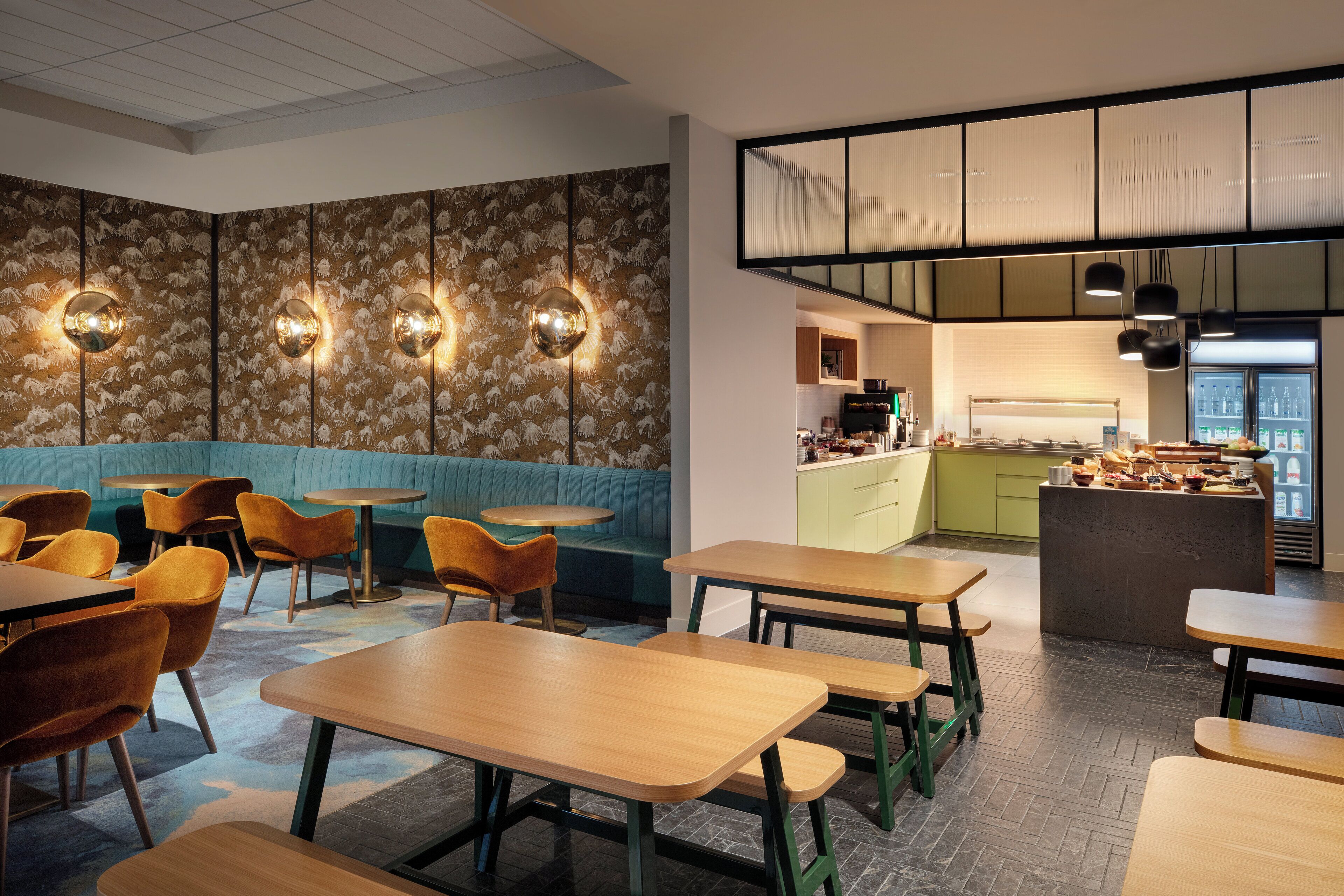 A restaurant interior with booths, tables, and a kitchen area.