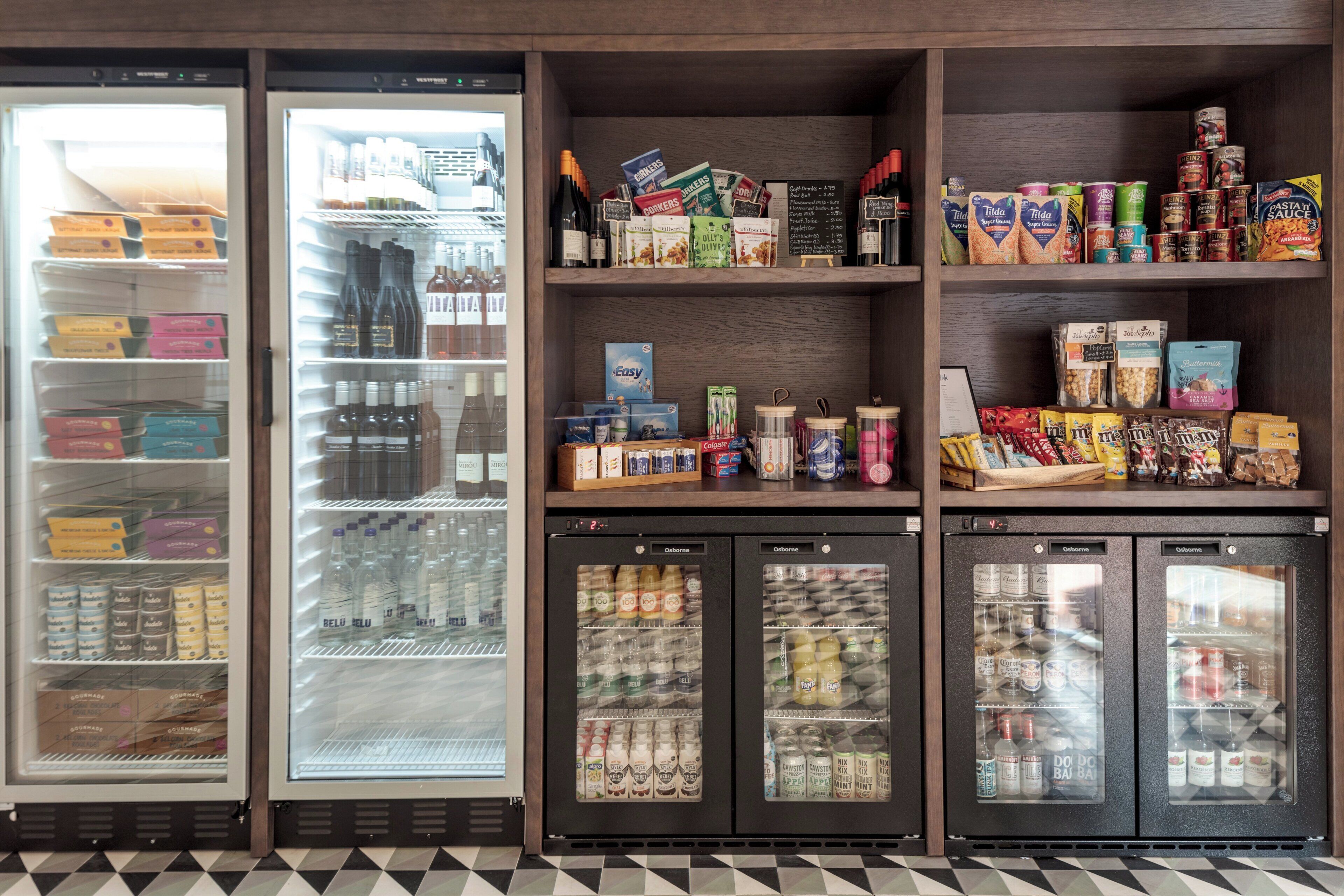 Mostrador refrigerado con diversas bebidas y aperitivos.